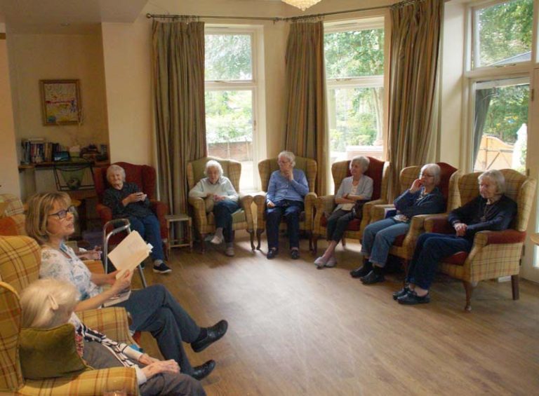 Lou, one of Heathfield's owners, reads poetry in the sun lounge