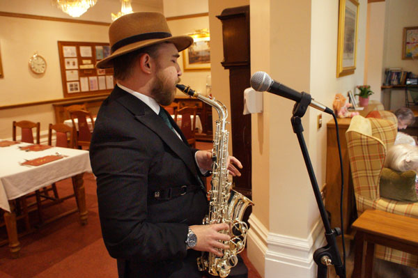 A saxophonist entertains the residents in the sun lounge