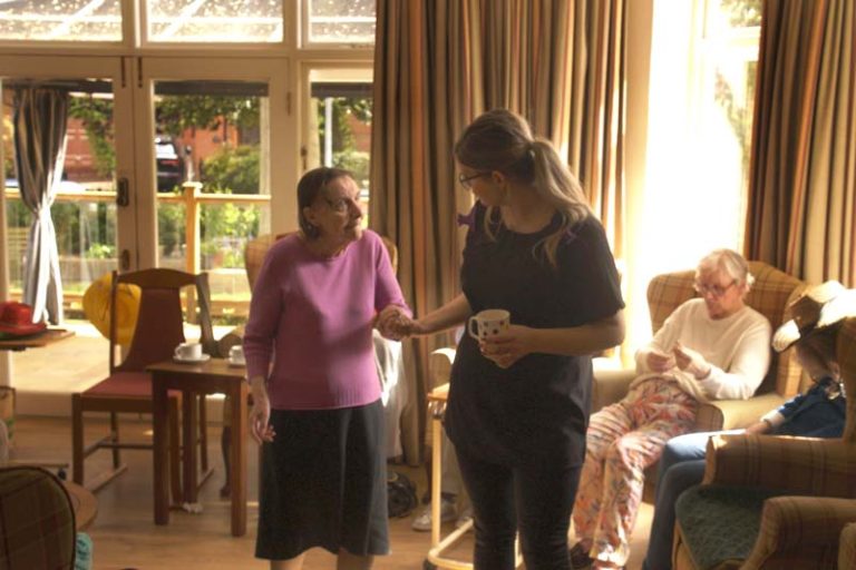 A care worker at Heathfield takes a resident's hand