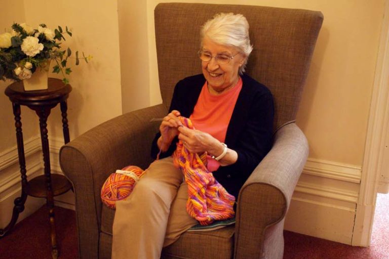 A Heathfield resident is knitting in a comfortable chair