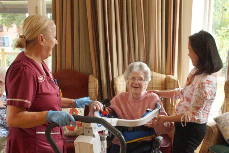 Manager Marjorie and a care worker enjoy a joke with a resident
